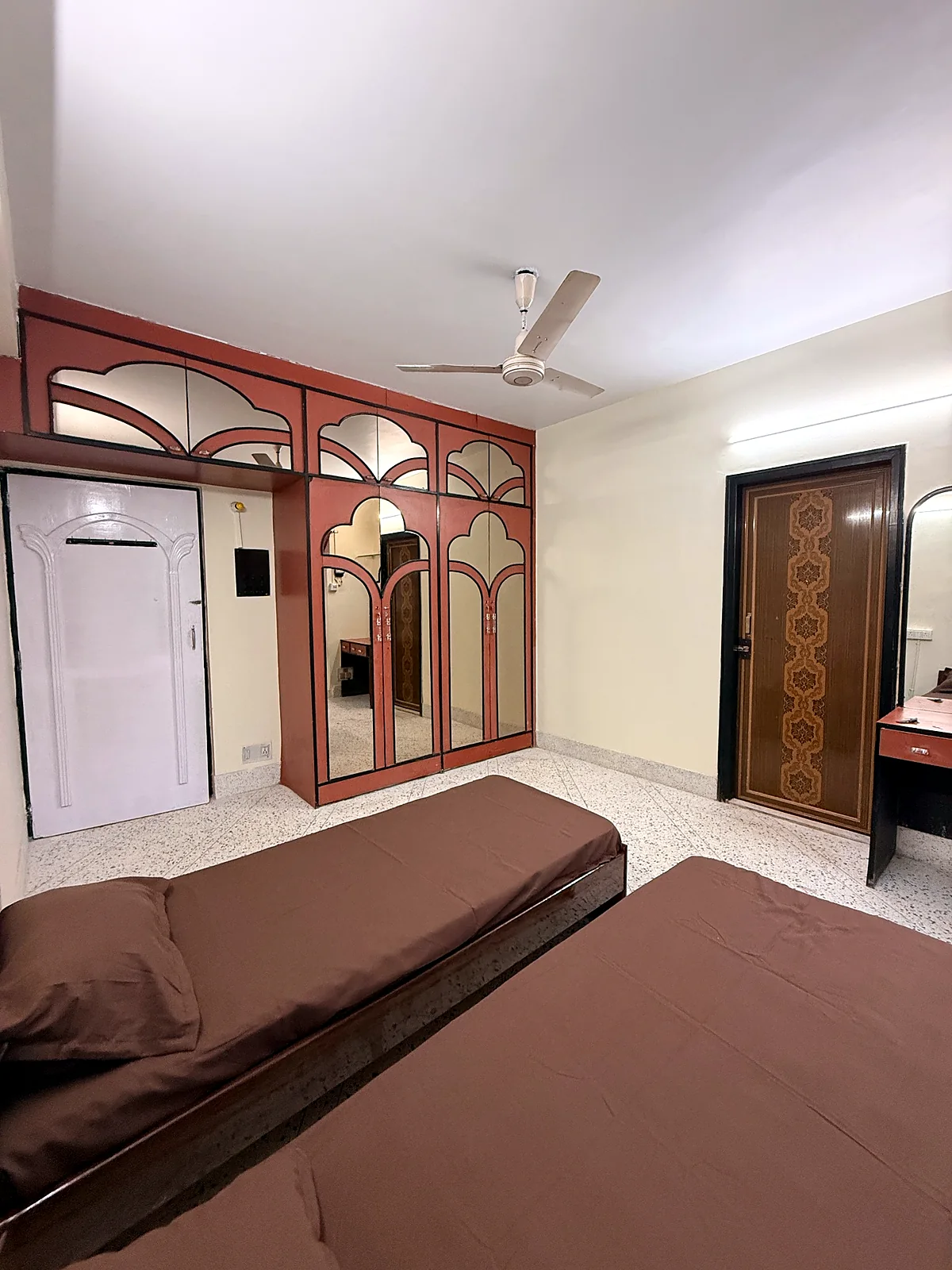 Twin-sharing room at Snehmili Girls PG with built-in mirrored wardrobes and individual beds