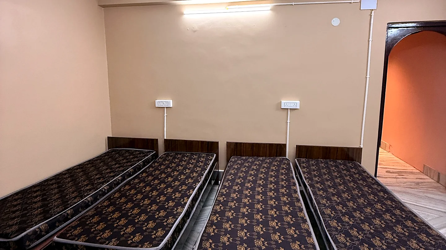 Spacious four-sharing room with individual beds and wall-mounted charging points